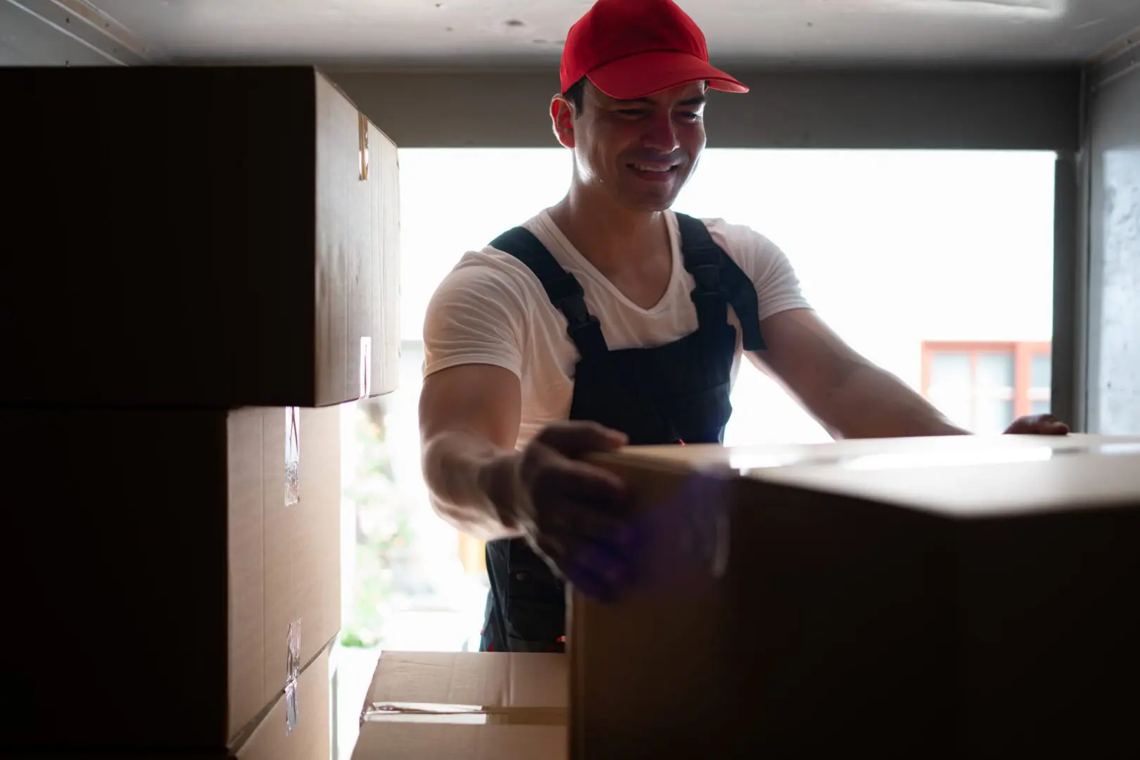 Mover smiling while handling a cardboard box.