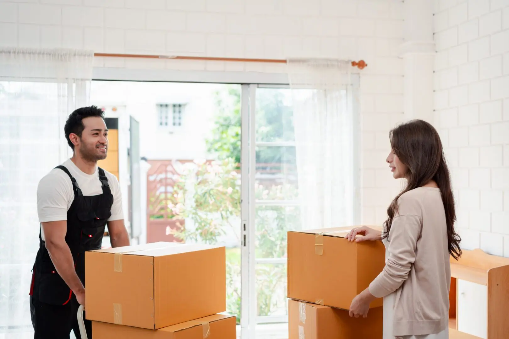 Mover and client discussing box arrangements indoors.