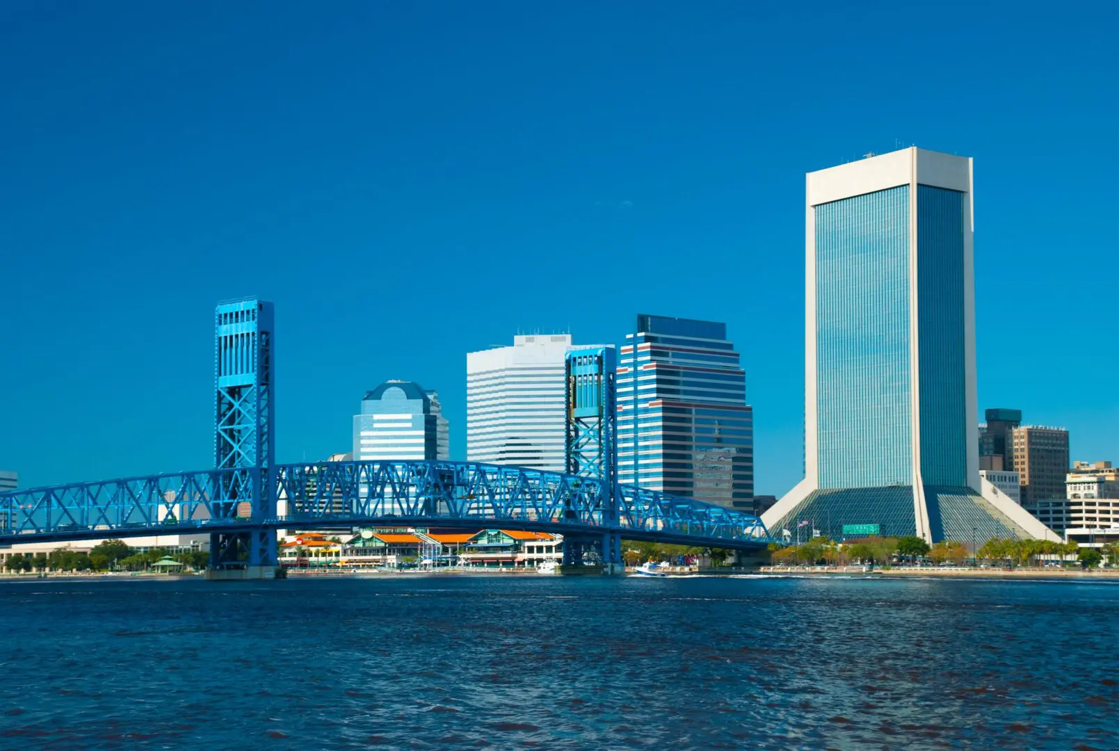 Jacksonville skyline with blue bridge and water.